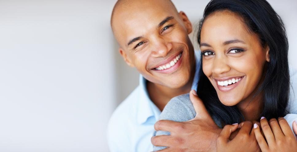 man smiling with his wife after having a dental crown put in